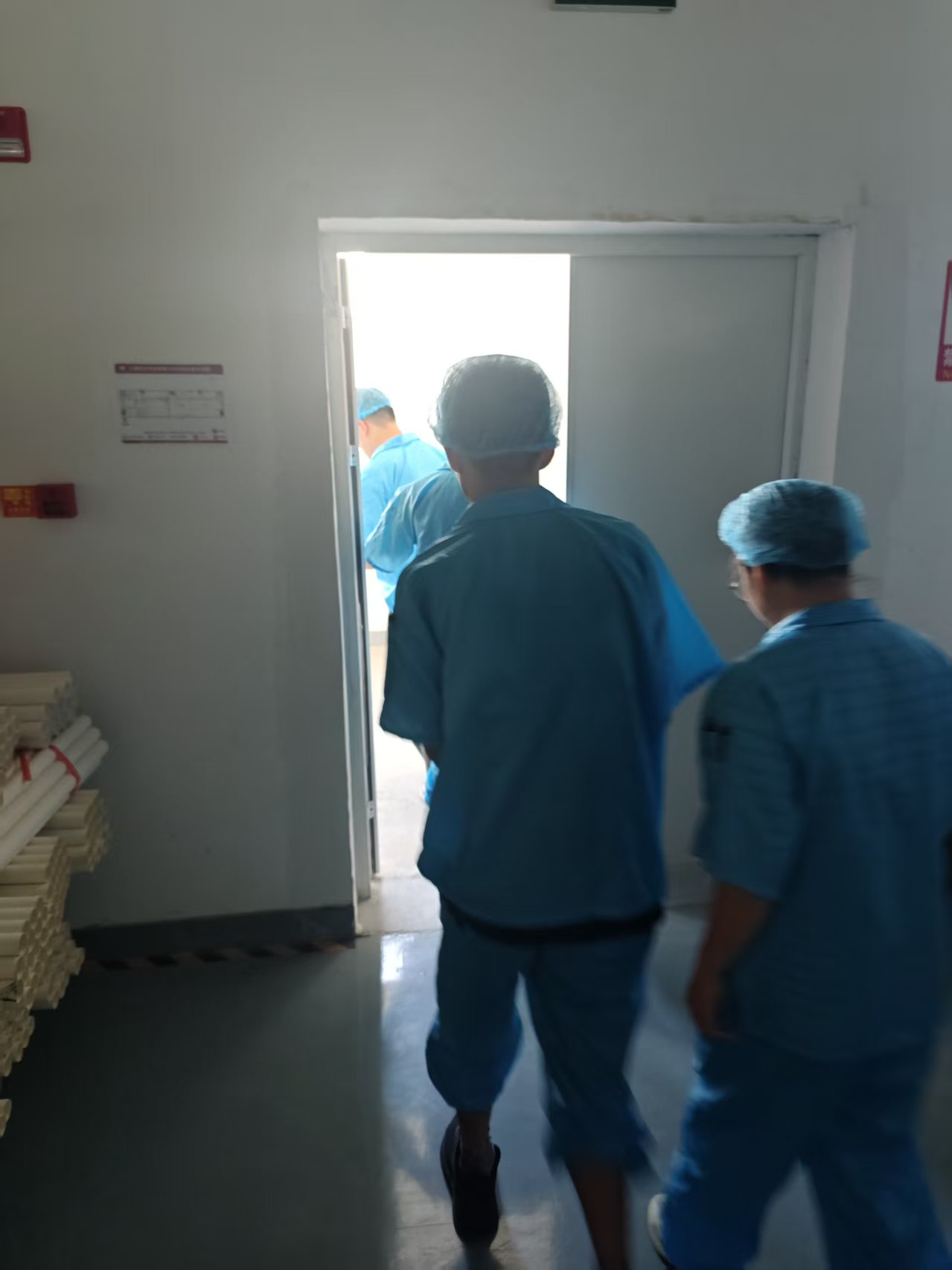 生产车间员工身穿蓝色工服从车间应急通道有序撤离至安全区域