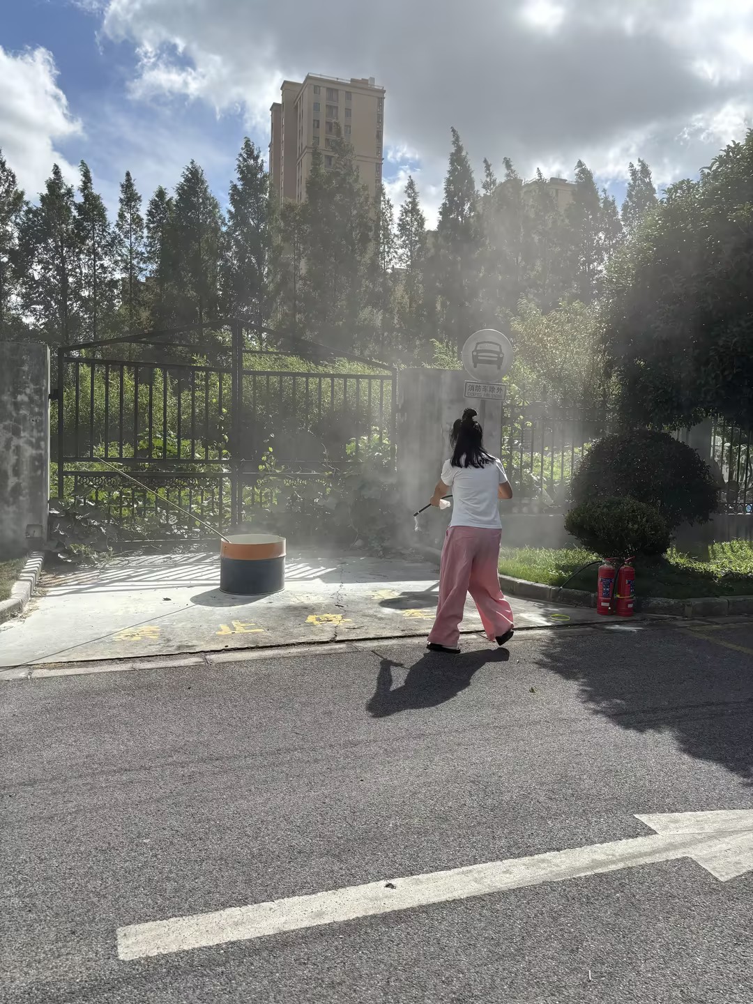 员工在公司门口使用干粉灭火器对准火桶根部喷射扑救实操演练